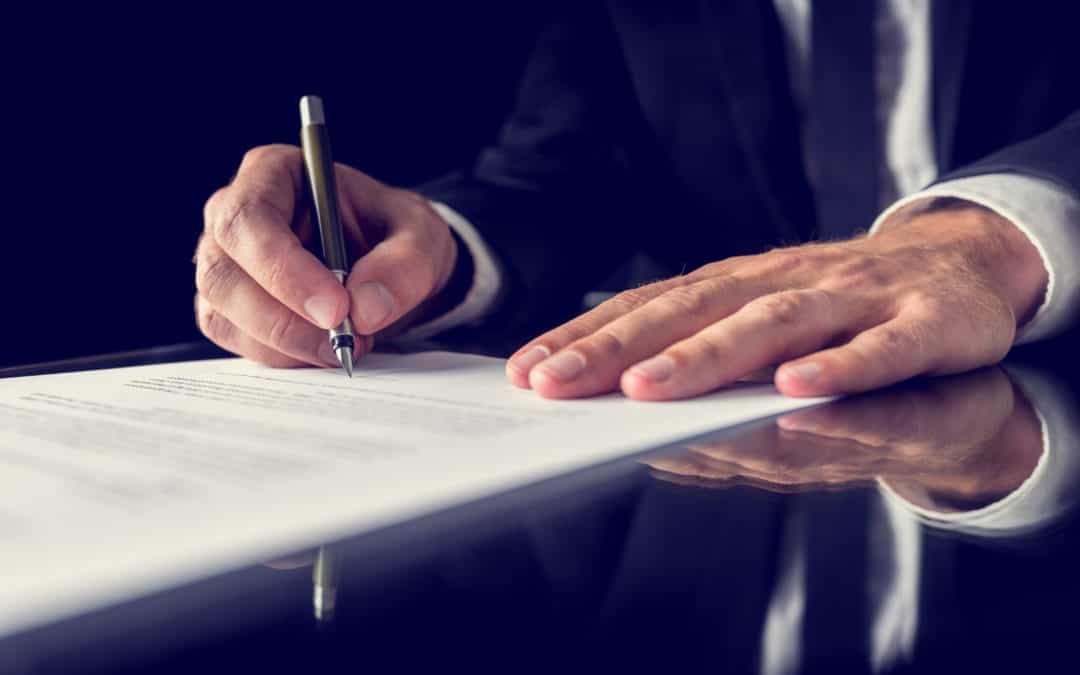 A man in California signing a document with a pen.