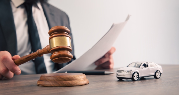 A lemon law attorney sitting at a desk with a gavel in front of him.