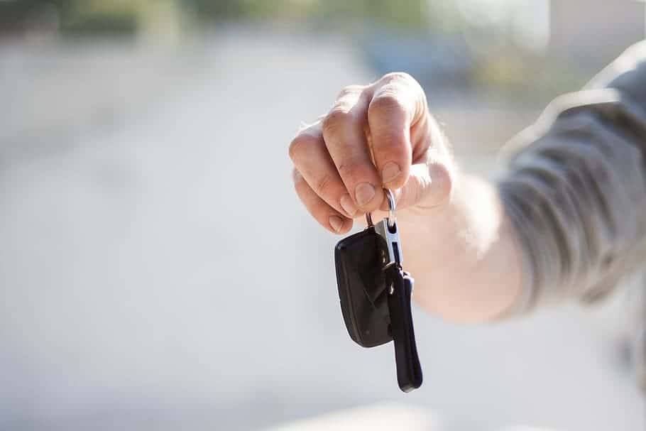 A man, possibly in California or San Diego, holding a car key in his hand.