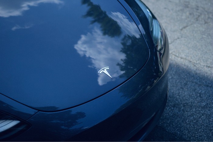 A blue Tesla Model S with a cloud logo on the hood potentially needing assistance from a California lemon law lawyer.