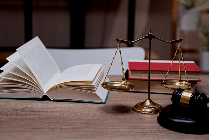 A lemon law attorney's book and scales displayed on a table.