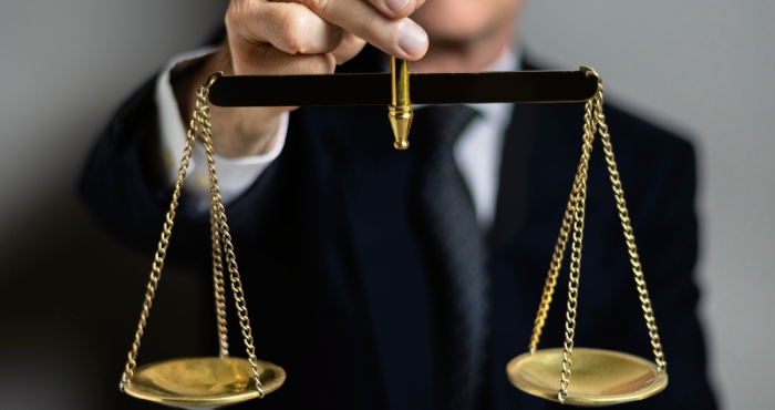 A man in a suit is writing on a piece of paper while consulting with a San Diego lemon law lawyer.