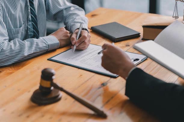 Top Benefits Of Partnering With A California Lemon Law Attorney: A lawyer signing a document with a gavel.