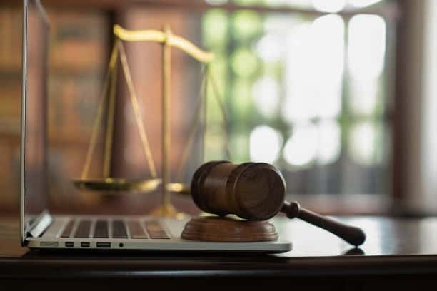 A laptop sits on top of a wooden gavel, highlighting common misconceptions about California Lemon Law.