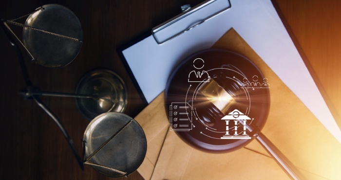 A gavel and scales sit on a table alongside a clipboard and envelope, with an overlay of legal symbols and a courthouse icon, reflecting the courtroom success achieved by Lemon Law Attorneys.